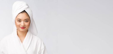 Bornozlu mutlu bir Asyalı kadının portresi. Beyaz arka planda izole edilmiş..