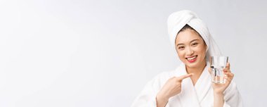 Sağlıklı, su içen genç, güzel bir kadın. Yüzü doğal makyajlı, beyaz arka planda soyutlanmış..