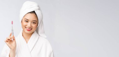 Bornozlu, diş fırçası olan Asyalı mutlu kadın. Sabah havasında.