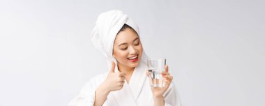 Sağlıklı, su içen genç, güzel bir kadın. Yüzü doğal makyajlı, beyaz arka planda soyutlanmış..