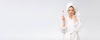 Mutsuz güzel kadın beyaz arka planda dişlerini fırçalıyor.