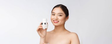 Beyaz, soyutlanmış arka planda güzel bir kadın elinde kozmetik yüz kremi, Asyalı