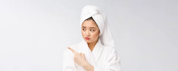 Jovem mulher bonita usando toalha de chuveiro após o banho sobre fundo branco isolado apontando com o dedo . — Fotografia de Stock
