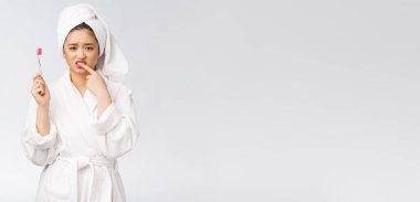 Mutsuz güzel kadın beyaz arka planda dişlerini fırçalıyor..