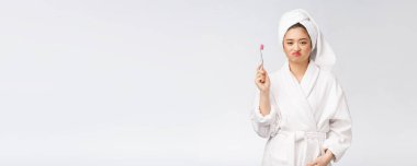 Mutsuz güzel kadın beyaz arka planda dişlerini fırçalıyor.