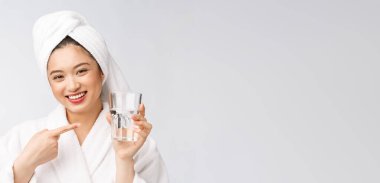 Sağlıklı, su içen genç, güzel bir kadın. Yüzü doğal makyajlı, beyaz arka planda soyutlanmış..