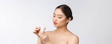 Beyaz, soyutlanmış arka planda güzel bir kadın elinde kozmetik yüz kremi, Asyalı