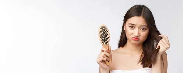 Kesal menekankan wanita muda Asia memegang rambut kering yang rusak di tangan atas putih terisolasi latar belakang . — Stok Foto