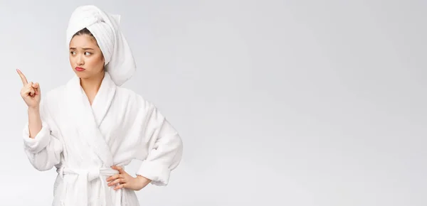 Junge schöne Frau trägt Duschtuch nach dem Bad über isolierten weißen Hintergrund zeigt mit dem Finger. — Stockfoto