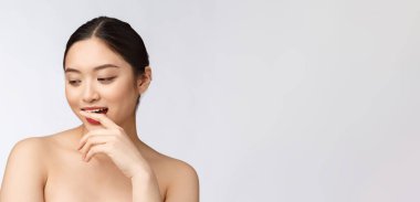 Güzellik merkezi Asyalı kadın duş tedavisinden sonra saçlarını kurutuyor. Güzel çok ırklı genç kız yumuşak tene dokunuyor.