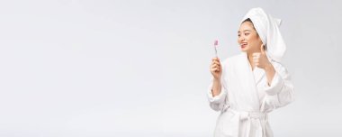 Bornozlu, diş fırçası olan Asyalı mutlu kadın. Sabah havasında.