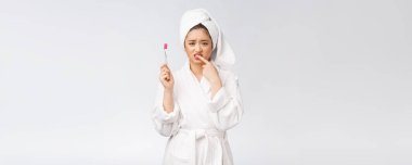 Mutsuz güzel kadın beyaz arka planda dişlerini fırçalıyor.