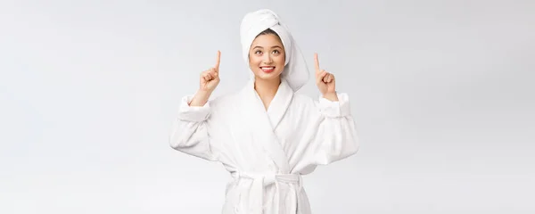 Schönheitsporträt einer jungen Frau, die mit dem Finger auf leeren Kopierraum zeigt, asiatische Schönheit im Bademantel. — Stockfoto