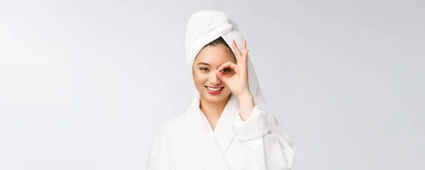 Primo piano di giovane donna sorridente con dito ok gesto sugli occhi, isolato su sfondo bianco — Foto Stock