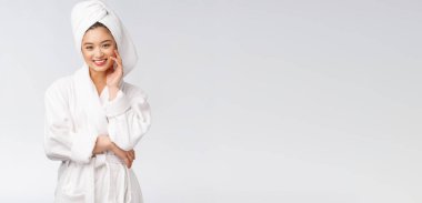 Bornozlu mutlu bir Asyalı kadının portresi. Beyaz arka planda izole edilmiş..