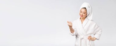 Tenini kontrol eden Asyalı güzel bir kız. Cilt bakımı Beyaz arkaplan üzerinde izole edilmiş.