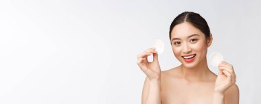 Cilt bakımı yapan kadın yüz makyajını pamuklu bezle temizliyor. Cilt bakımı konsepti. Mükemmel ciltli güzel melez ırk modelinin yüz görüntüsü..