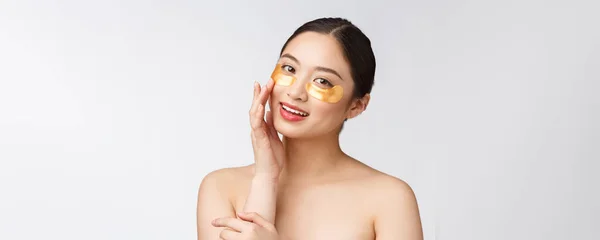 Ασιατική γυναίκα ομορφιά φροντίδα του δέρματος της με χρυσά μπαλώματα μάσκες ματιών κάτω από τα μάτια — Φωτογραφία Αρχείου