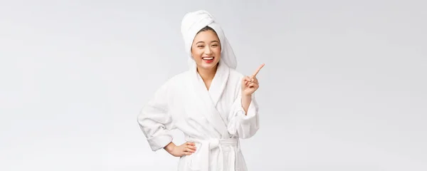 Beauty portrait of young woman showing and pointing finger to empty copy space, asian beauty in bathrobe. — Stock Photo, Image