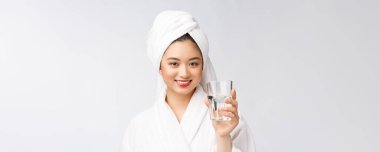 Sağlıklı, su içen genç, güzel bir kadın. Yüzü doğal makyajlı, beyaz arka planda soyutlanmış..