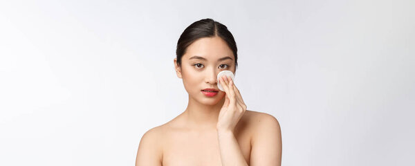 skin care woman removing face makeup with cotton swab pad - skin care concept. Facial closeup of beautiful mixed race model with perfect skin.