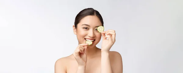 Masques faciaux naturels au concombre frais faits maison. Femme asiatique tenant des tampons de concombre et sourire se détendre avec naturel fait maison — Photo