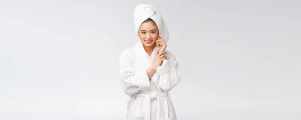 Portret van een jonge gelukkige aziatische dame in badjas. Geïsoleerd in witte achtergrond. — Stockfoto