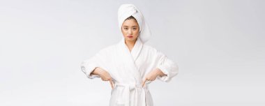 İzole edilmiş beyaz arka planda duş havlusu takan güzel bir kadın parmak ile işaret ediyor..