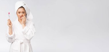 Mutsuz güzel kadın beyaz arka planda dişlerini fırçalıyor.