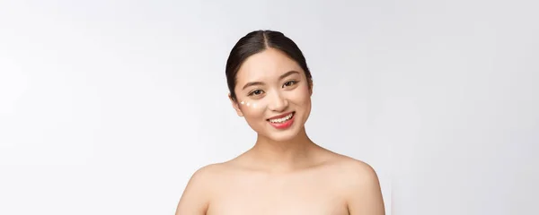 Mulher beleza cuidados da pele. Mulher de beleza sorrindo aplicando creme. Retrato de beleza de belo modelo feminino asiático caucasiano isolado em branco . — Fotografia de Stock