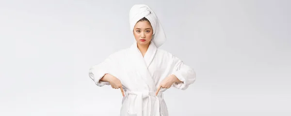 Молода красива жінка носить душовий рушник після ванни над ізольованим білим тлом, вказуючи пальцем . — стокове фото