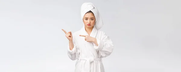 Young beautiful woman wearing shower towel after bath over isolated white background pointing with finger. — Stockfoto