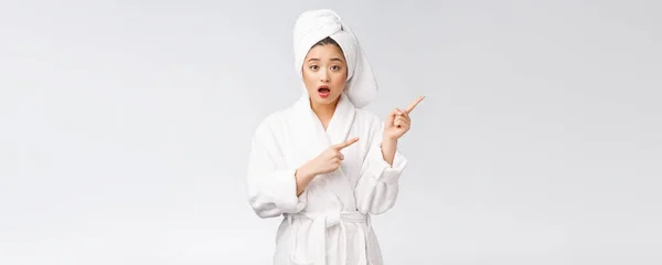 Fiatal gyönyörű nő visel zuhany törölköző fürdés után elszigetelt fehér háttér mutatva ujjal. — Stock Fotó