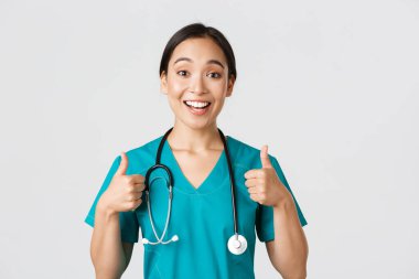 Sağlık çalışanları, virüsü önleme, karantina kampanyası konsepti. Genç ve destekleyici Asyalı hemşire onayladı. Doktor neşelen, birini cesaretlendir ya da iltifat et.