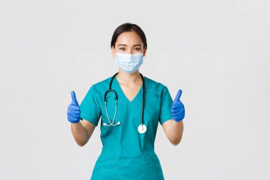 Covid-19, koronavirüs hastalığı, sağlık çalışanları konsepti. Kendine güvenen profesyonel doktor, Asyalı doktor, kişisel koruyucu ekipman, hastaya garanti ve güvence, tıbbi maske takın.