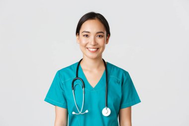 Sağlık çalışanları, virüsü önleme, karantina kampanyası konsepti. Gülümseyen hoş Asyalı kadın hemşire, önlüklü doktor neşeli görünüyor, hasta dinliyor, beyaz bir geçmişi var.