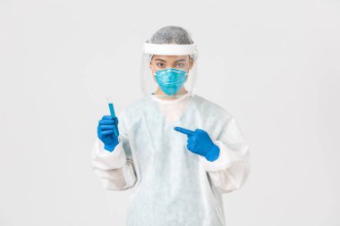 Covid-19, koronavirüs hastalığı, sağlık çalışanları konsepti. Ciddi bir kendinden emin Asyalı kadın araştırmacının portresi, test tüpünde aşı tutan kişisel koruyucu ekipman laboratuvar çalışanı