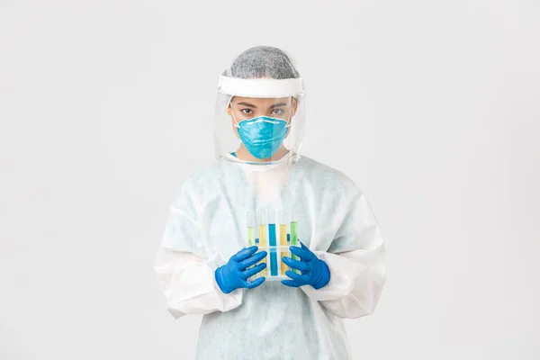 Covid-19, coronavirus disease, healthcare workers concept.认真、细心的亚洲女性技术实验室工作人员，个人防护设备研究人员，拿着装有疫苗的试管 — 图库照片