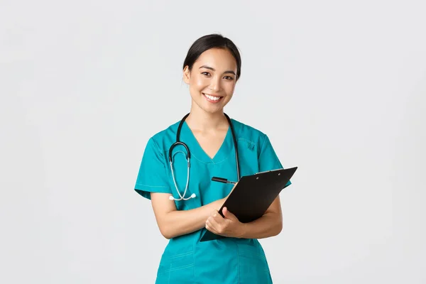 医療従事者ウイルスの予防隔離キャンペーンの概念。陽気フレンドリーなアジアの女性医師,毎日の検査中にクリップボードを持つ医師,立って白い背景 — ストック写真