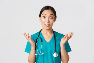 Sağlık çalışanları, virüsü önleme, karantina kampanyası konsepti. Şaşırmış ve eğlenmiş, mutlu Asyalı kadın hemşire, doktor harika haberler duyup, ellerini kaldırıp kameraya bak.
