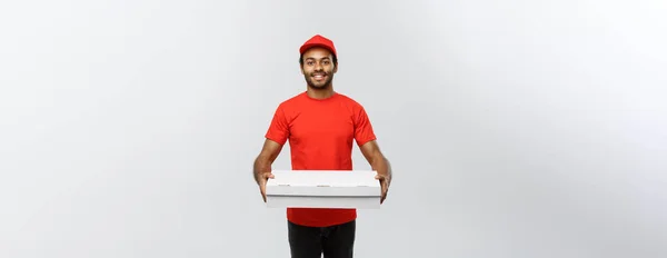 Concepto de entrega - Retrato del guapo repartidor de pizza afroamericana. Aislado en Grey studio Background. Copiar espacio . —  Fotos de Stock