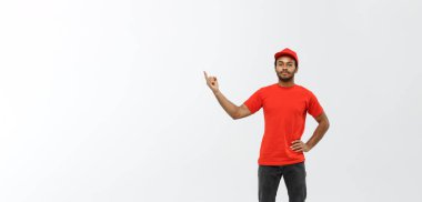 Teslimat Konsepti - Mutlu Afro-Amerikalı teslimatçının portresi bir şey sunmak için işaret ediyor. Grey Stüdyo Arkaplanı 'nda izole edilmiş. Boşluğu Kopyala.