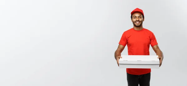 Concetto di consegna Ritratto di bello afroamericano Pizza uomo di consegna. Isolato su sfondo grigio studio. Copia spazio. — Foto Stock