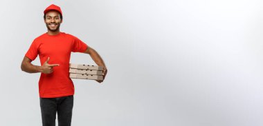 Teslimat kavramı - mutlu Afrika kökenli Amerikalı teslimat adam el işaret kutusunu paket sunuyoruz portresi. Arka plan gri studio izole. Kopya alanı.