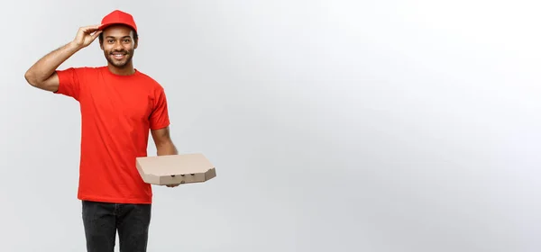 Αντίληψη παράδοσης - Πορτρέτο του Όμορφος αφρικανική αμερικανική πίτσα delivery man. Απομονωμένος στο Grey studio Background. Αντιγραφή χώρου. — Φωτογραφία Αρχείου