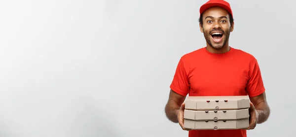 Conceito de entrega - Retrato de bonito afro-americano entregador de pizza. Isolado no estúdio Grey Background. Espaço de cópia . — Fotografia de Stock