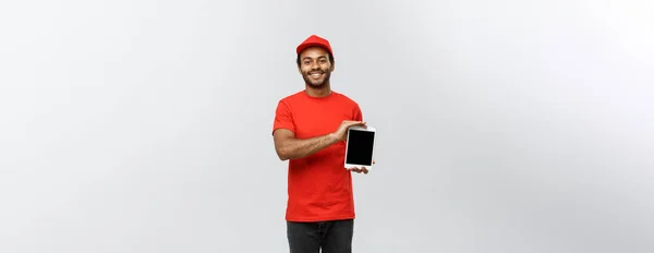 Delivery Concept - Portrait of Handsome African American delivery man or courier showing tablet on you to check the order. Isolated on Grey studio Background. Copy Space. — Stock Photo, Image