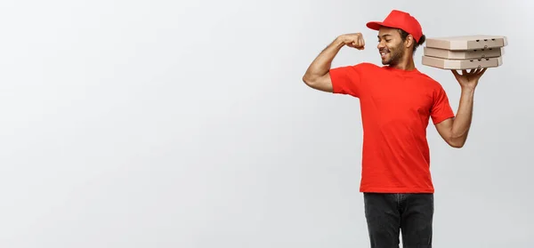 Lieferkonzept - Porträt eines starken afrikanisch-amerikanischen Zustellers, der seine Muskeln mit Pizzakartonverpackungen zeigt. isoliert auf grauem Studiohintergrund. Kopierraum. — Stockfoto