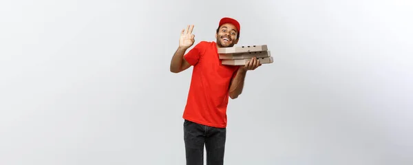 Conceito de entrega - Retrato de bonito afro-americano entregador de pizza. Isolado no estúdio Grey Background. Espaço de cópia . — Fotografia de Stock