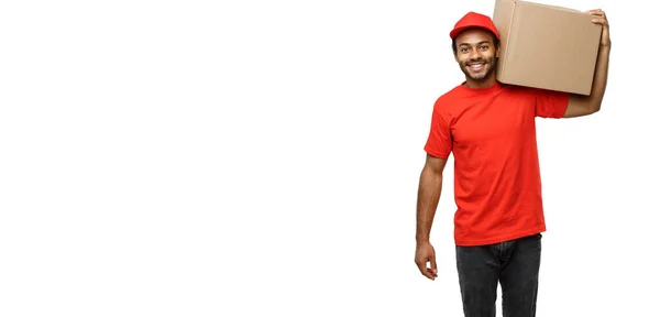 Conceito de entrega - Retrato de homem de entrega afro-americano feliz em pano vermelho segurando um pacote de caixa. Isolado no estúdio branco Background. Espaço de cópia — Fotografia de Stock